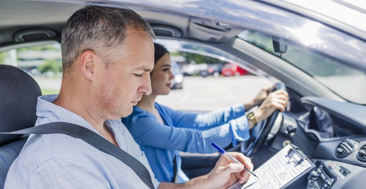instructor-driving-school-giving-exam-while-sitting-car